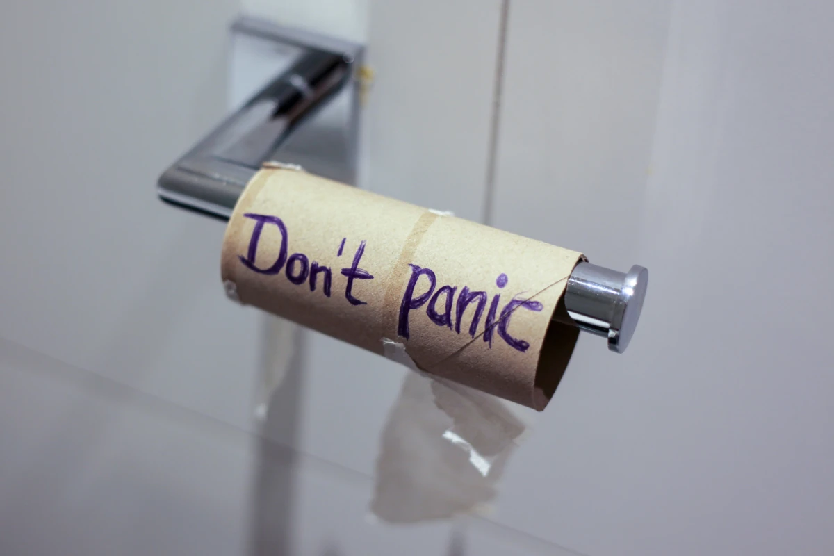 An empty roll of toilet paper with the words "Don't Panic" written on it